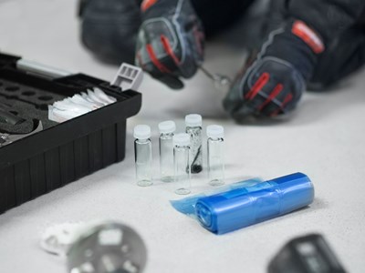 Tre tekniker står i ett källarutrymme och diskuterar. 