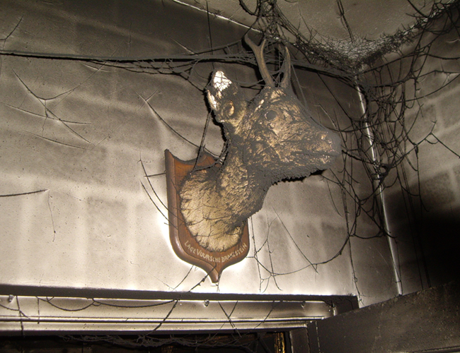 Roetschade na brand langs muur en plafond