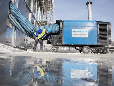 En tekniker vid en stor avfuktare utomhus. 